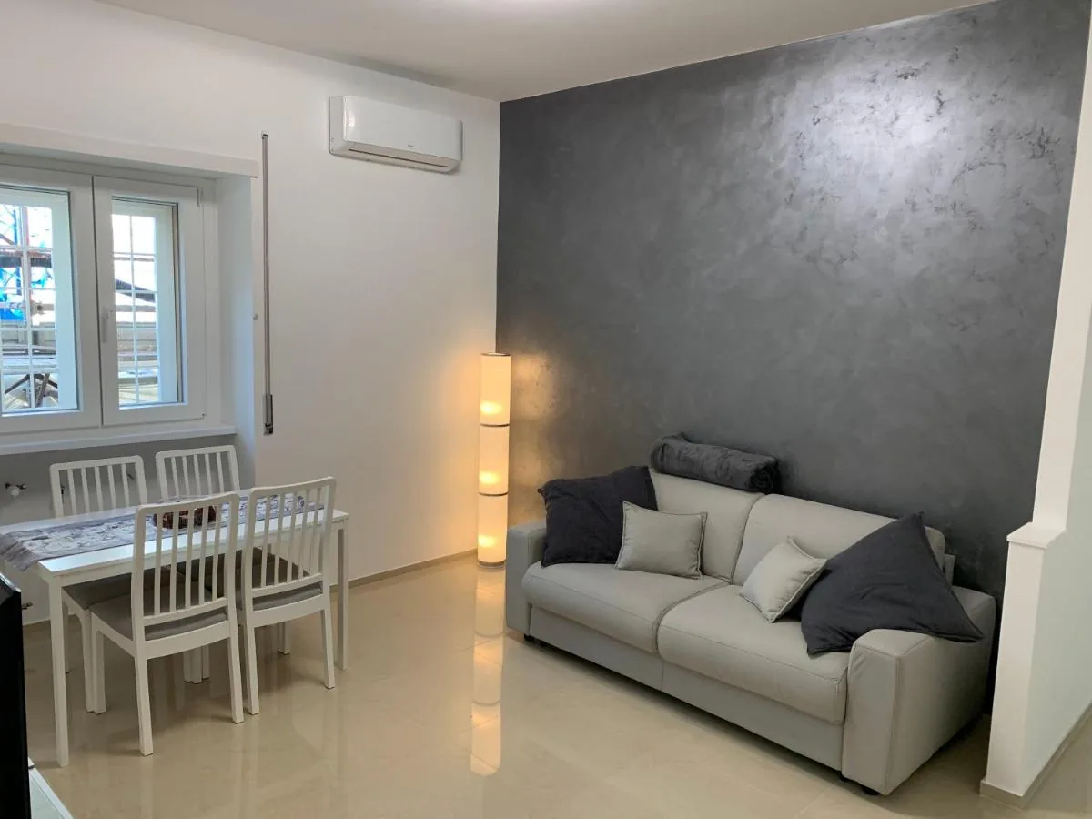 A Casa di Elisa — Il soggiorno con il divano letto, il tavolo da pranzo e il climatizzatore