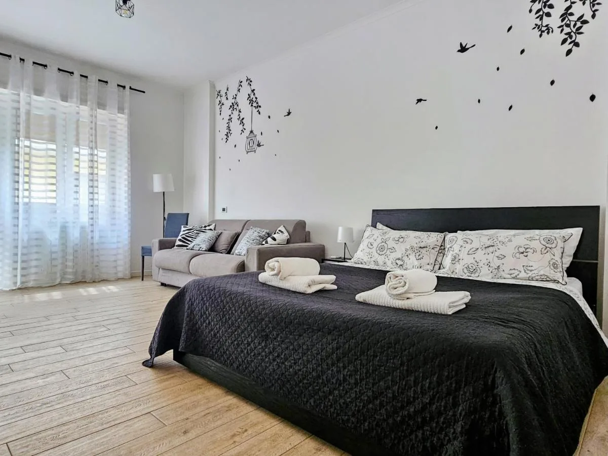 Il monolocale Maremè Guest House con il letto matrimoniale e il divano sullo sfondo